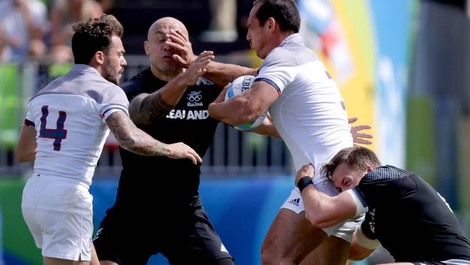 DJ Forbes of New Zealand takes a hand to the face from Damien Cler of France during a rugby sevens match at Deodoro Stadium in the Rio 2016 Summer Olympic Games.