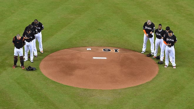 Marlins teammates gather around the mound for a moment of silence.