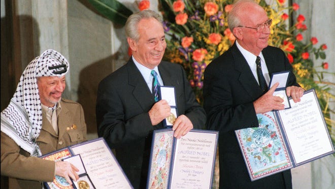 (FILES) Palestinian leader Yasser Arafat (L), former Israeli Foreign Minister Shimon Peres and late Israeli Premier Yitzhak Rabin pose in Oslo in this 10 December 1994 file picture with their Nobel Peace prizes. Arafat is in a coma and in an "extremely bad state", on life support at the Percy military hospital in Clamart, southwest of Paris, French medical sources told AFP, 04 November 2004. AFP PHOTO/FILES/MENAHEM KAHANA ORG XMIT: MAG35
