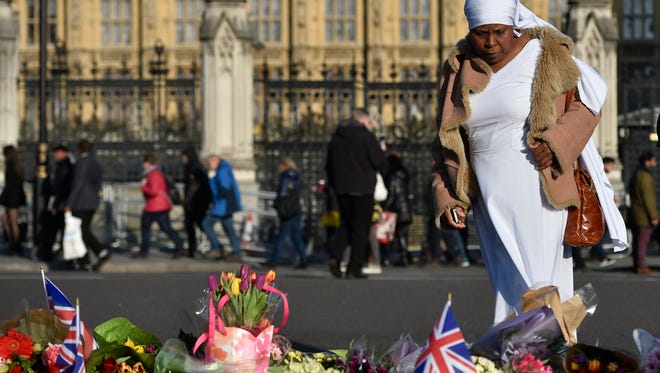 A woman looks at flowers in Parliament Square near Tuesday's rampage scene.