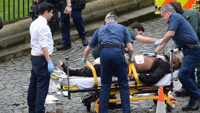 In this March 22, 2017 file photo, the attacker Khalid Masood is treated by emergency services outside the Houses of Parliament London. British Police named on  March 23, 2017,  Khalid Masood as The Houses of Parliament attacker.