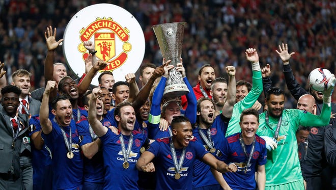 Members of Manchester United celebrate winning the Europa League final on Wednesday.