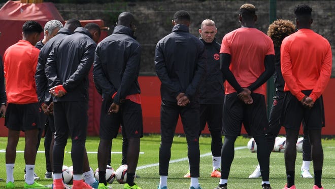 Manchester United's English striker Wayne Rooney stands with teammates as they observe a minute's silence for the victims of yesterday's terror attack at the Ariana Grande concert during a team training session in England May 23, 2017.
