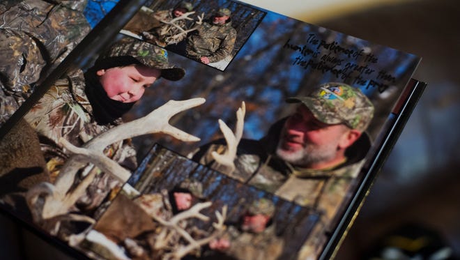 Bill Kohler flips through a book of photographs from his son Ayden's first deer hunting trip this winter. The community has rallied around Ayden after he was diagnosed with cancer, helping him to make the most of his time.