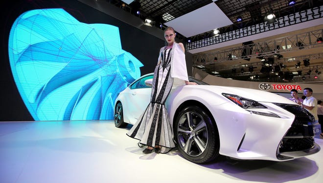 A model stands next to a Lexus RC Turbo at The Vietnam Motor Show, the RC is in the Large luxury car category.