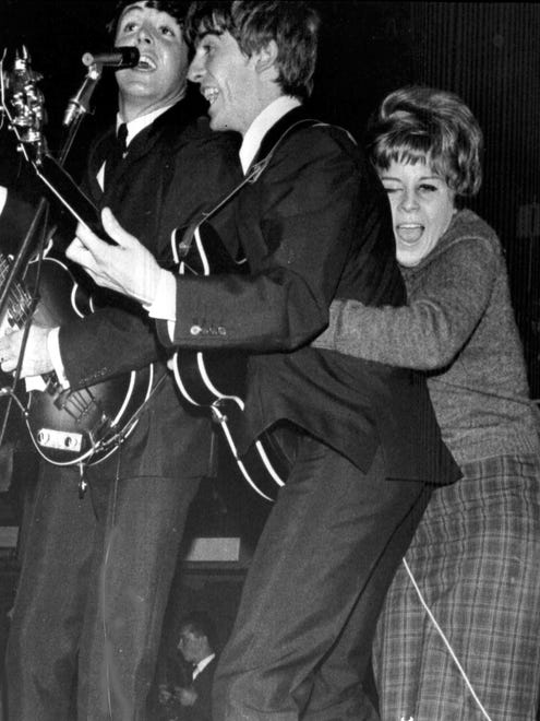 As Beatlemania exploded, fans were hands-on in their love for the group. A young admirer hugs George Harrison on Oct. 26, 1963, as The Beatles play at a pop festival in Stockholm. "The kids, I never felt they were trying to hurt us," Starr says.