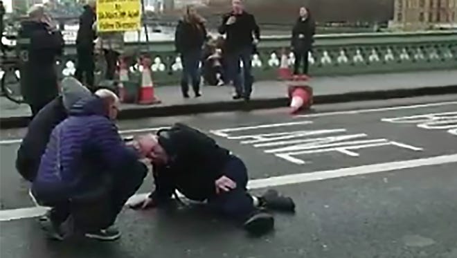 An video grab obtained from the Twitter account of Polish politician and journalist Radosaw Sikorski, shows a man on the ground receiving assistance on Westminster Bridge after a shooting incident in London.