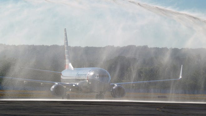 An American Airlines plane gets a water-cannon salute as it arrives to Havana's Jose Marti International Airport on Monday, Nov. 28, 2016.