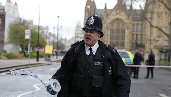 A police officer sets up a police cordon outside the Houses of Parliament in central London on March 22, 2017 during an emergency incident.