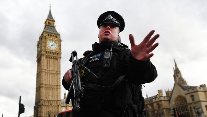 Armed police push people back following a shooting incident outside the Houses of Parliament in London.