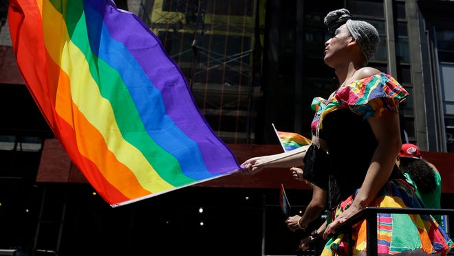 People on a float dance and wave flags during the annual pride parade in New York.