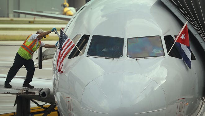An employee closes a door on American Airlines Flight 903 as it is prepared to push back from the gate, becoming the first commercial flight from Miami to Cuba in 55-years on Sept. 7, 2016.