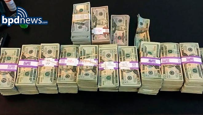 In this photo released by the Boston Police Department, stacks of money totaling about $187,000 that were left in a taxi are displayed in Boston.