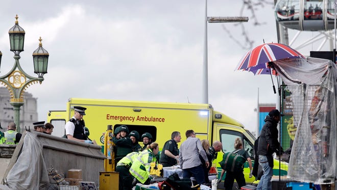 Emergency services staff provide medical attention close to the Houses of Parliament in London.