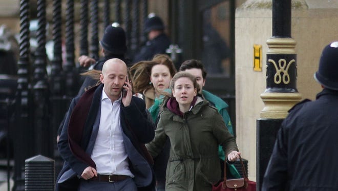 People leave after being evacuated from the Houses of Parliament in central London.
