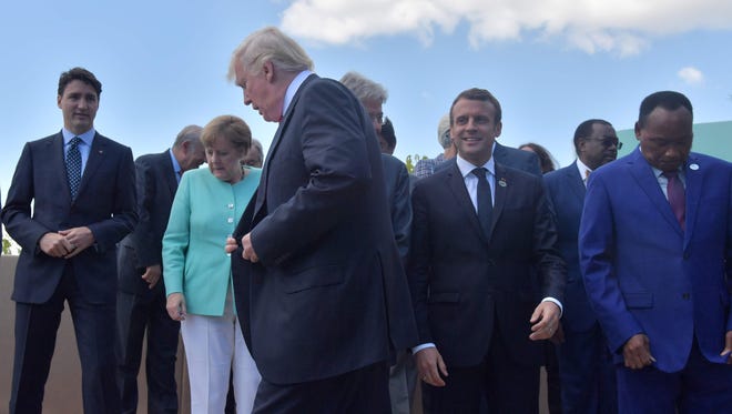 President Trump walks past Canadian Prime Minister Justin Trudeau, German Chancellor Angela Merkel, French President Emmanuel Macron and Niger's President Mahamadou Issoufou at a "family photo" with leaders of the G7 and African countries in Taormina, Sicily on Saturday.