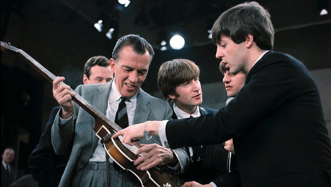 Paul McCartney, right, shows his guitar to Ed Sullivan before The Beatles' live appearance on the show. "I wasn't a crazy music follower, I didn't have the radio going constantly," Howard says. "But they were on all the time, and I loved it.'