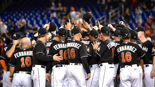 The Marlins players embrace on the pitchers mound.