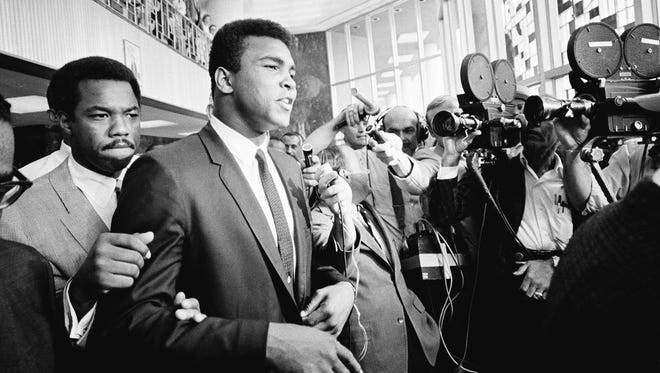 In this June 19, 1967, file photo, Muhammad Ali leaves the federal building in Houston during a recess in his trial for refusing induction to the Army.