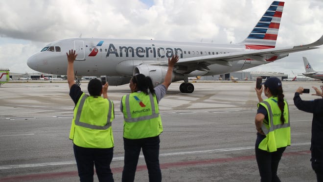 Employees watch as American Airlines Flight 903 prepares for take off, becoming the first commercial flight from Miami to Cuba in 55 years on Sept. 7, 2016.