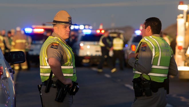 Arizona state troopers converge on the scene Jan. 12, 2017, of a rollover accident near mile marker 89 on Interstate 10 west of Tonopah, Ariz., where another trooper was ambushed after coming upon the wreck.