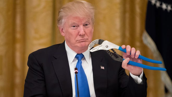 President Trump is pictured holding a jaw plier during a meeting at the White House with company representatives who featured products made in the U.S.