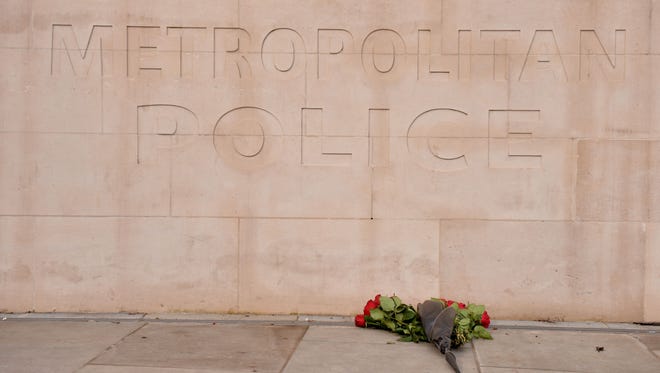 A bunch of roses lays at the Metropolitan Police headquarters at New Scotland Yard in central London on March 23, 2017 during a moment of silence.