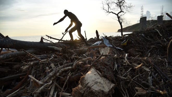 A man collects debris from a destroyed house in the small village of Labey in southwest of Haiti on Oct. 11.