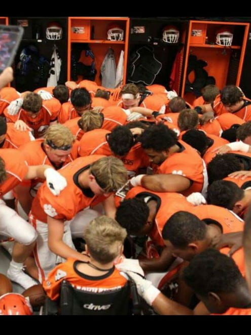 Members of the Central York football team pray with 9-year-old Ayden Ziegler-Kohler before Friday's season opener. After he was diagnosed with brain cancer last month, Ayden was named an honorary captain for Central's opener, leading the team onto the field for the game against West York.