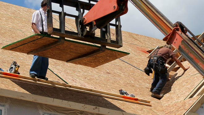 Builders work on the roof of a home under construction at a housing plan in Jackson Township, Butler County, Pa. On Friday, June 23, 2017, the Commerce Department reports on sales of new homes in May.