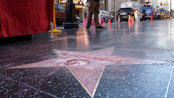 A man stands near a cordoned-off area surrounding the vandalized star honoring Donald Trump on the Hollywood Walk of Fame. Detective Meghan Aguilar said investigators were called to the scene before dawn Wednesday in response to reports that Trump's star was destroyed by blows from a hammer.