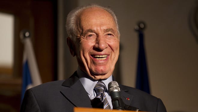 This file photo taken on July 14, 2011 shows Israeli President Shimon Peres laughing as he addresses the annual Bastille Day reception at the French ambassador's residence in Tel Aviv.