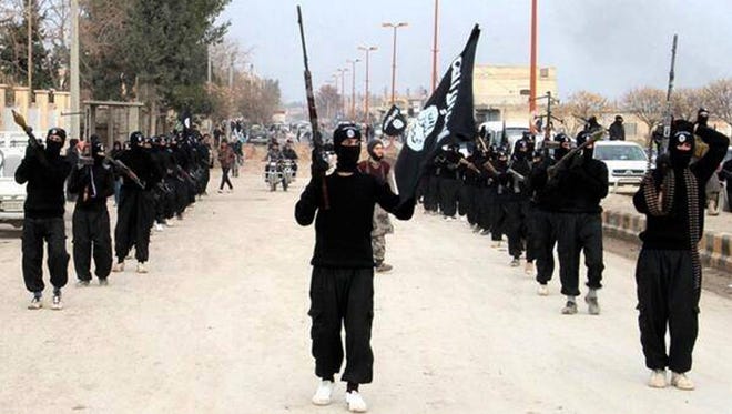 FILE - This undated file image posted on a militant website on Tuesday, Jan. 14, 2014 shows fighters from the al-Qaida linked Islamic State of Iraq and the Levant (ISIL) marching in Raqqa, Syria.