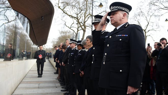 Metropolitan Police Service Acting Commissioner Craig Mackey (R) salutes during a minute of silence for their fallen officer, PC Keith Palmer, outside New Scotland Yard in London on March 23, 2017. Scotland Yard said that police have made seven arrests in raids carried out over night in Birmingham London and elsewhere in the country after the terror attack in the Westminister Palace grounds and on Westminster Bridge on March 22. 2017 leaving four people dead, including the attacker, and 29 people injured.