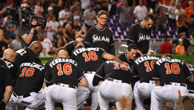 Marlins manager Don Mattingly watches as his team takes a knee around the pitchers mound to honor Jose Fernandez after defeating the Mets 7-3 at Marlins Park.