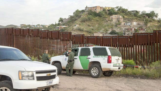 U.S. Border Patrol agents patrol the border fence in Nogales, Ariz.