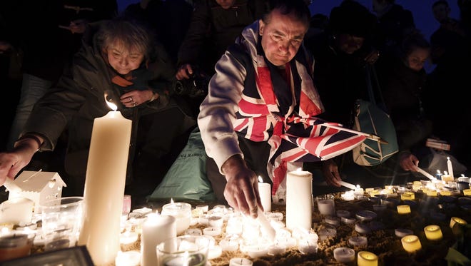 Members of the public light candles during a candlelit vigil at Trafalgar Square on March 23, 2017, in London.