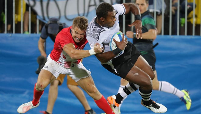 Great Britain back Tom Mitchell (6) throws Fiji forward Leone Nakarawa (5) to the grass during a rugby sevens gold medal match between Fiji and Great Britain at Deodoro Stadium in the Rio 2016 Summer Olympic Games.