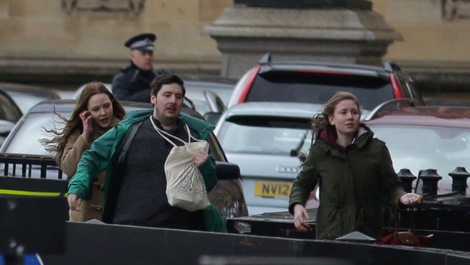 People leave after being evacuated from the Houses of Parliament in central London.
