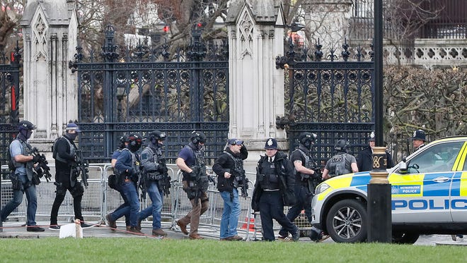 Armed police officers enter the Houses of Parliament in London after a reported shooting.