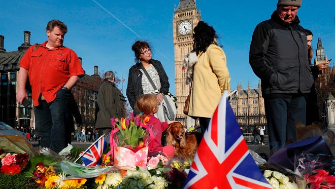 People lay floral tributes to the victims of the March 22 terror attack in Parliament Square outside the Houses of Parliament in central London on Friday. 
Counter-terrorism police commander Mark Rowley said nine people are now in custody over the rampage in Westminster, in which at least 50 people were injured, 31 requiring hospital treatment.