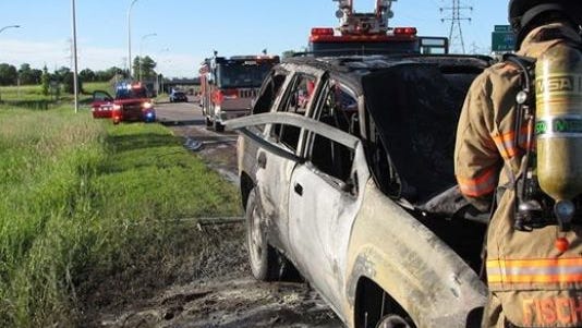 Fire crews clean up the scene where a motorist pulled a stranger from a burning SUV in Minnesota.
