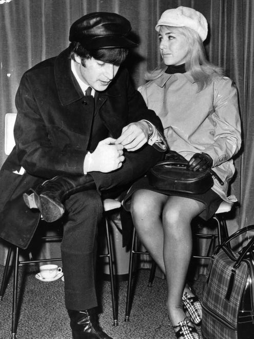 John Lennon and wife Cynthia wait for a flight to New York at London Airport on Feb. 7, 1964. "They would sit like this, four chairs with the wives and girlfriends," says the documentary's producer Nigel Sinclair. "There was a circle around them. ... People broke into that group at their peril."