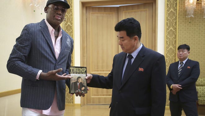 Former NBA basketball star Dennis Rodman presents a book titled "Trump The Art of the Deal" to North Korea's Sports Minister Kim Il Guk during a visit to Pyongyang on June 15, 2017.
