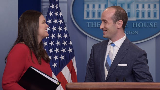 Sanders stands with White House senior policy adviser Stephen Miller during the daily briefing on Aug. 2, 2017.