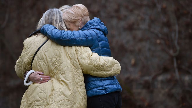 A group of women hug outside the Police Memorial where flowers have been laid near to the scene of the latest London terror incident.