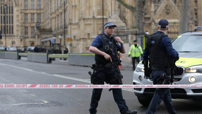 Armed police officers guard at a police cordon outside the Houses of Parliament in central London on March 22, 2017 during an emergency incident.