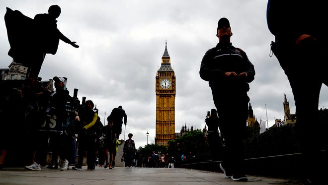 People walk around parliament square on election day in Westminster, London.