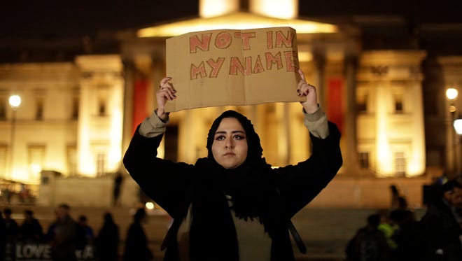 A woman holds up a sign at a vigil for the victims of Wednesday's attack, at Trafalgar Square in London on March 23, 2017.