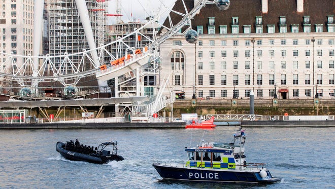 Police boats pass the London Eye as they patrol on the River Thames, near to the Houses of Parliament in London.